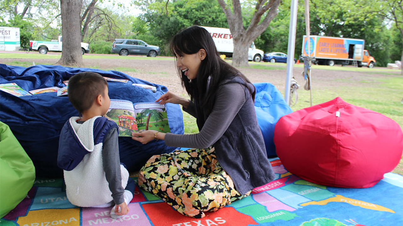 An adult reads to a young child