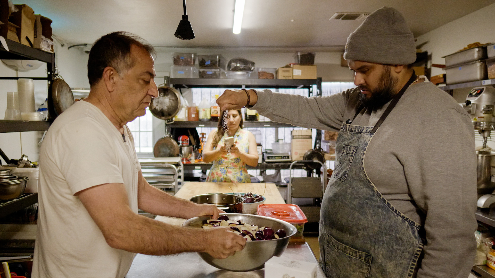 Edgar Rico sprinkles seasoning into a bowl of ingredients 