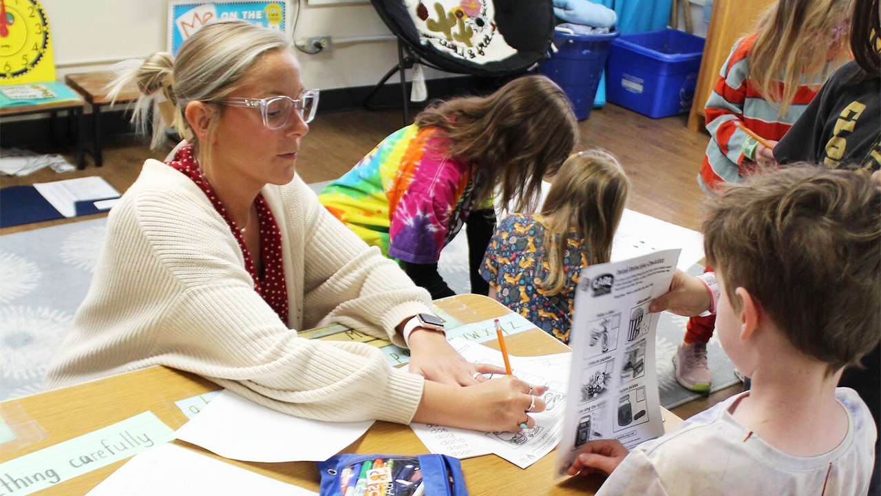An educator works with a young student