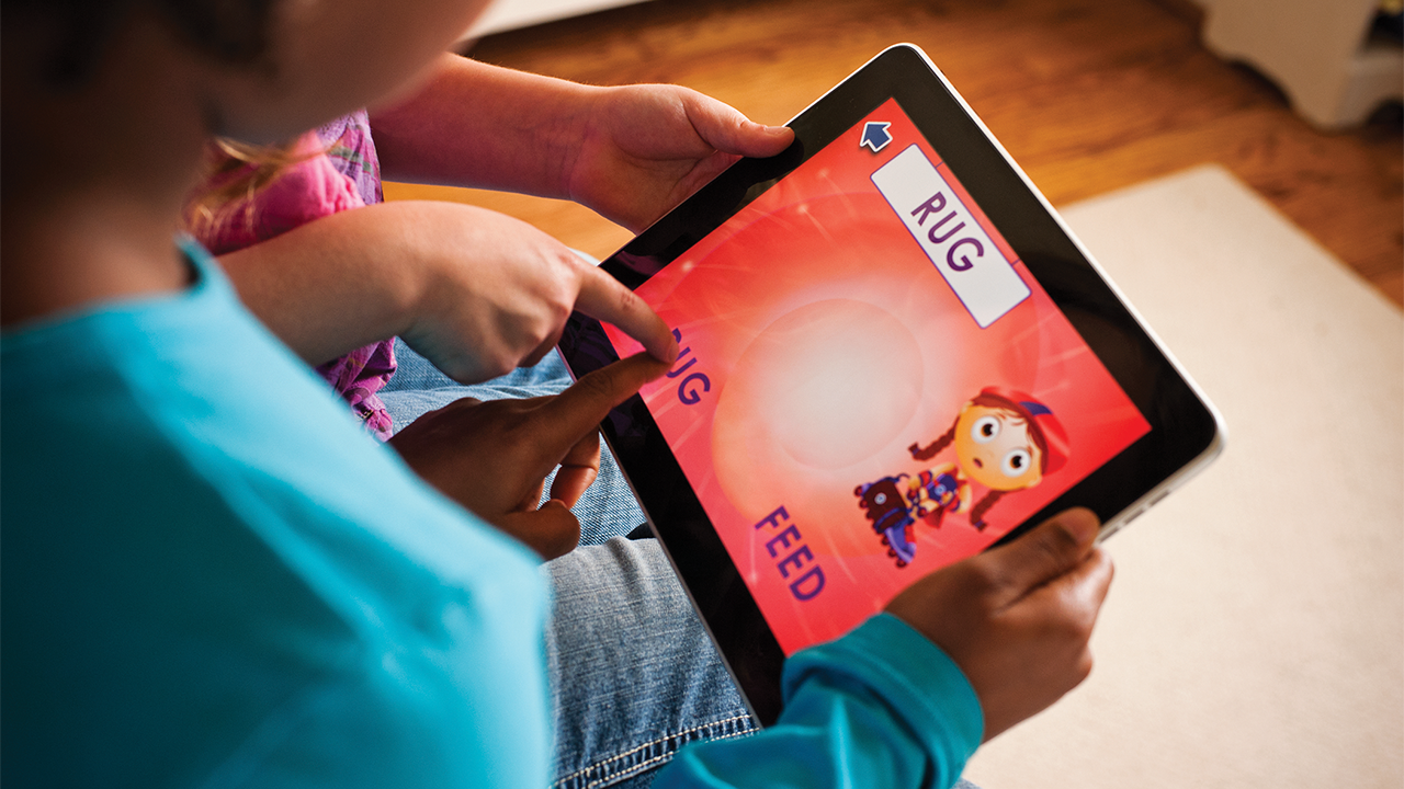 Two children play games on a tablet device