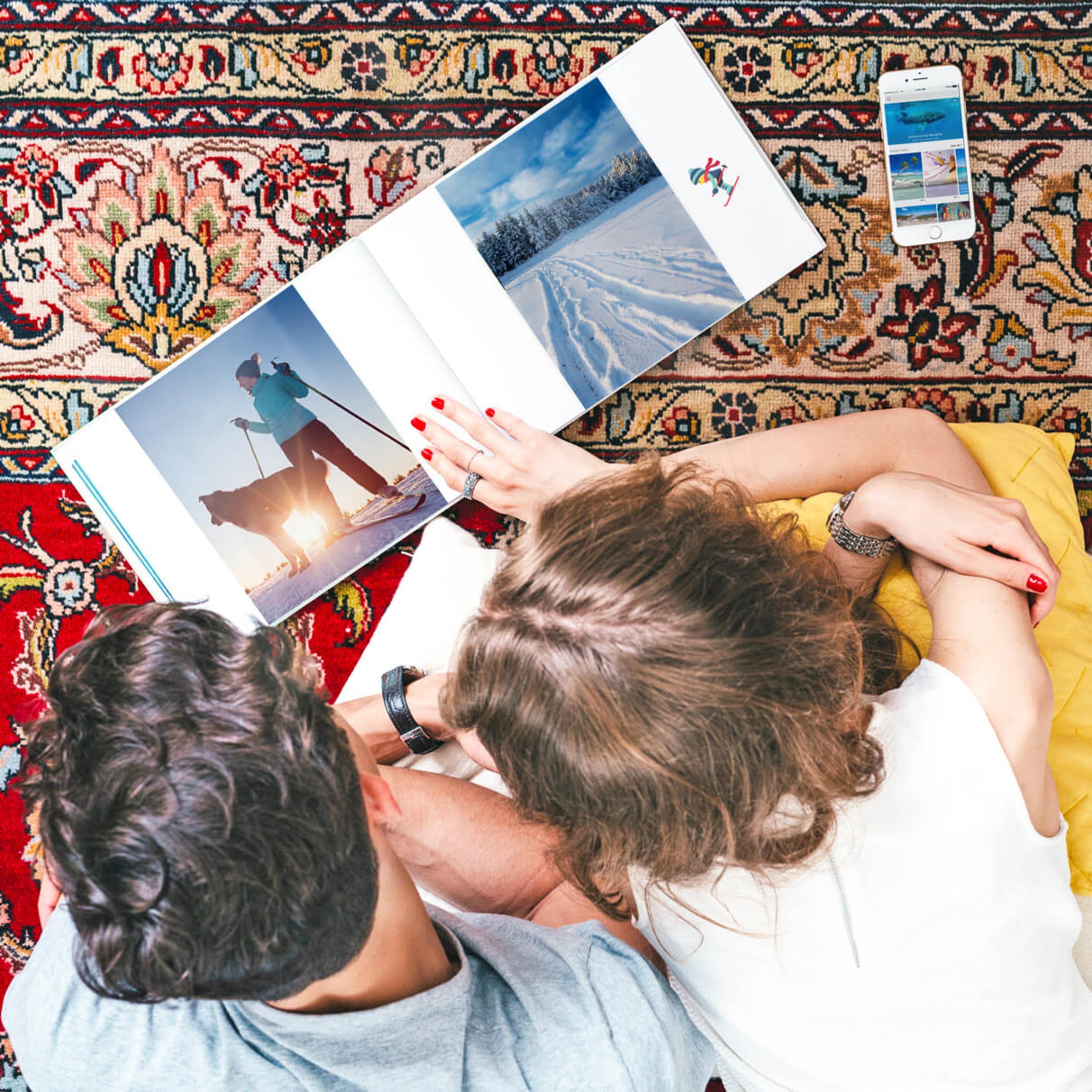 Couple in carpet, photo book with phone