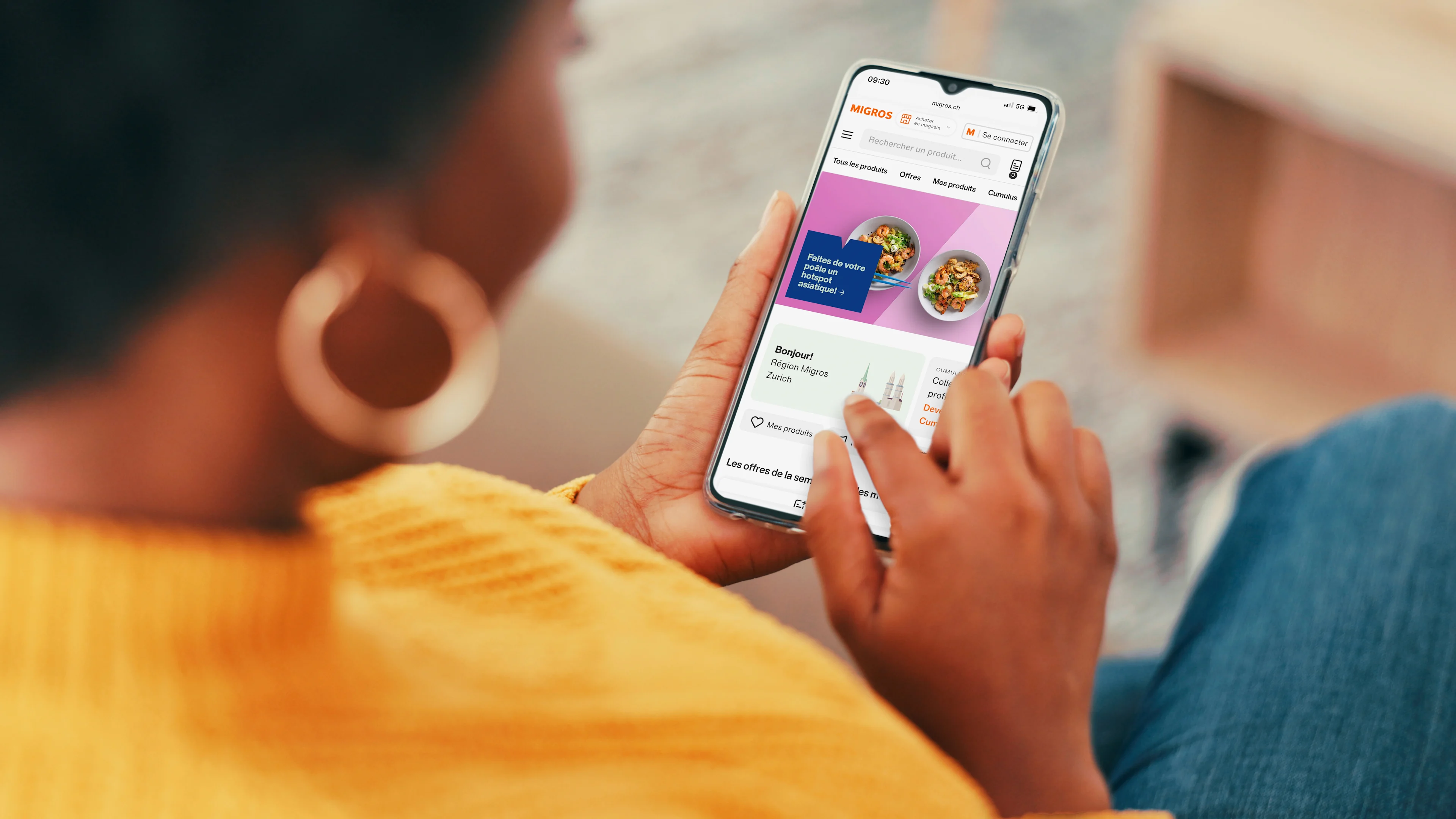Une femme qui est au téléphone et qui a ouvert le site Migros Online