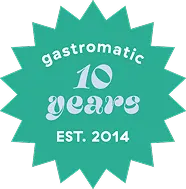 Ein tealfarbenes Starburst-Abzeichen mit der Aufschrift gastromatic 10 years EST. 2014 in weißer Schrift, zur Feier des 10-jährigen Jubiläums.