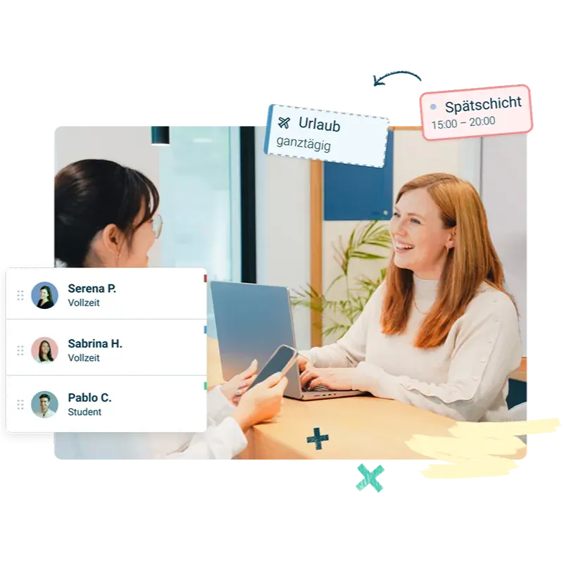 Zwei Frauen sitzen an einem Schreibtisch und unterhalten sich; eine lächelt mit einem geöffneten Laptop. Textkarten in deutscher Sprache zeigen Namen, Schichten und Beschäftigungsarten. Im Hintergrund sind helle Büroeinrichtungen und Fenster zu sehen.