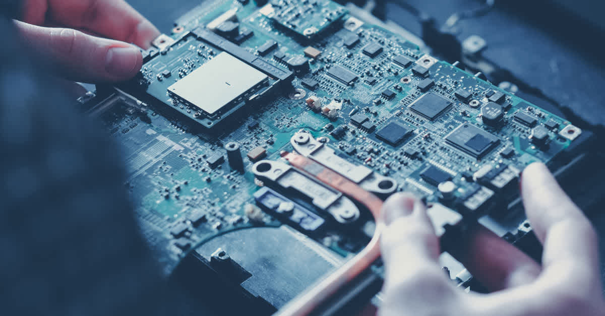 A person holding the motherboard with two hands A person holding the motherboard with two hands
