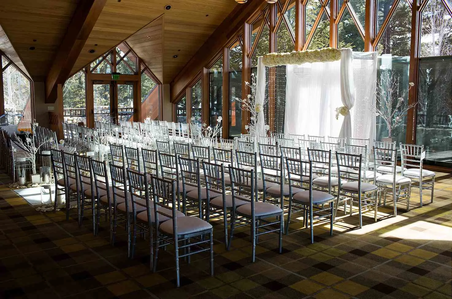 Wedding venue set up for an indoor winter ceremony. Source: https://www.brides.com/thmb/n0JY-1rt_cb9AyMVhewLmyjSRD4=/1500x0/filters:no_upscale():max_bytes(150000):strip_icc()/EdgewoodTahoeNorthRoom34-d46b9cd571c945389fc04054a569a0f7.jpg