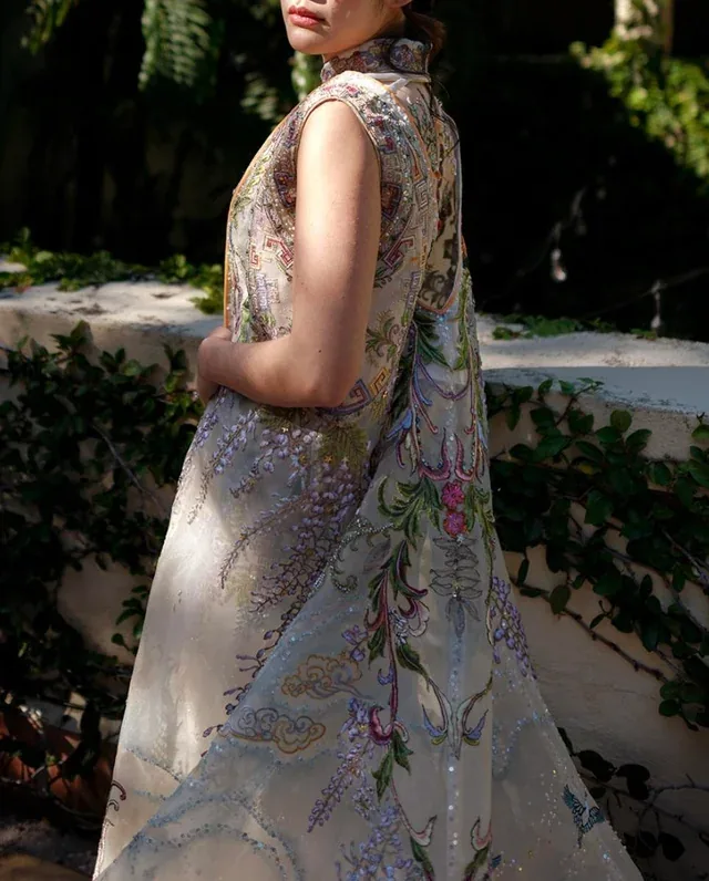 Purple wisteria drips off the sides of the dress. 