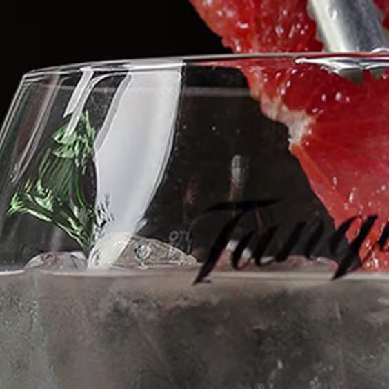 Un barman prepara el cóctel gin tonic con Tanqueray N° Ten y una rodaja de pomelo.