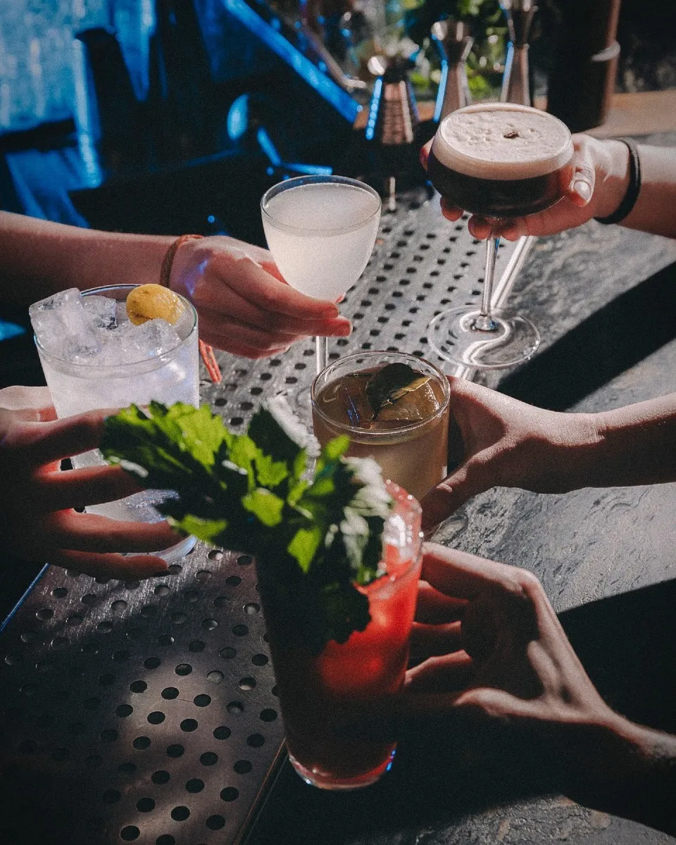 Un brindis con cócteles exquisitos en Club Sauvage, un lugar ideal para disfrutar de bebidas únicas en un ambiente sofisticado y acogedor.