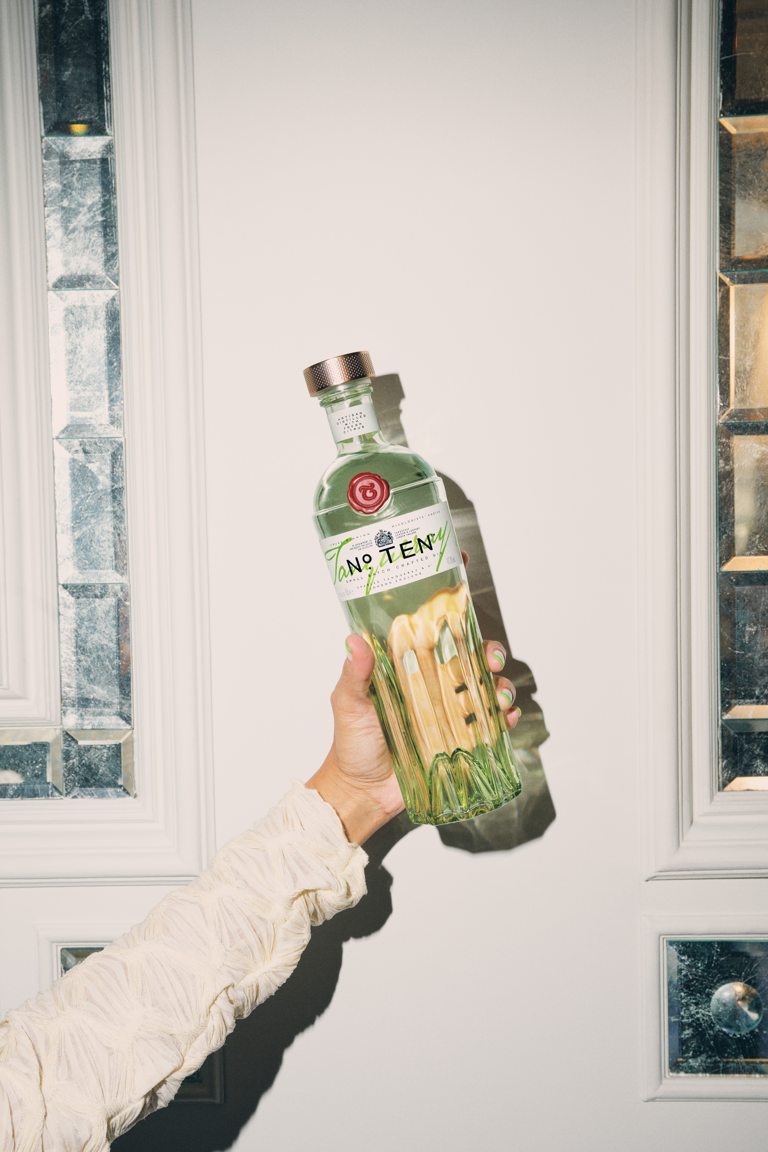 Tanqueray No. Ten Gin bottle being held in a brightly lit room