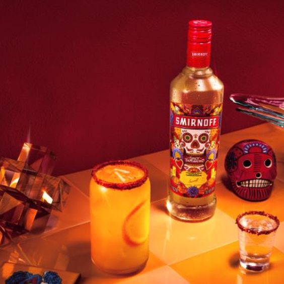 La imagen muestra una botella de vodka Smirnoff Spicy Tamarind con cócteles a su lado