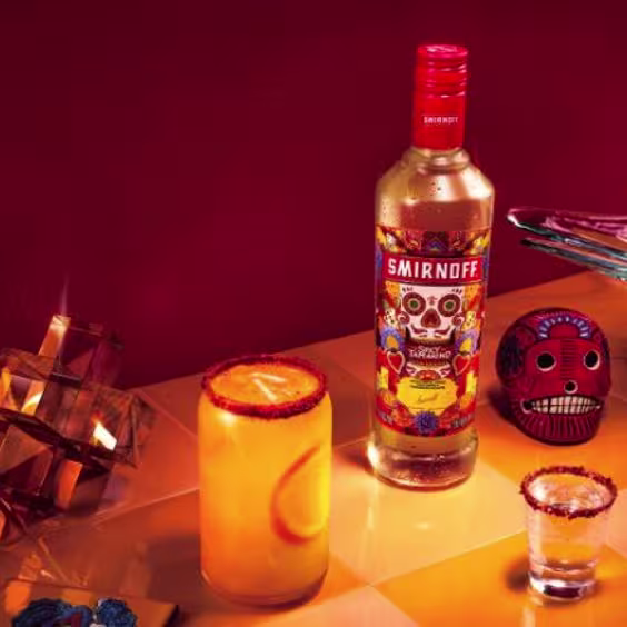 La imagen muestra una botella de vodka Smirnoff Spicy Tamarind con cócteles a su lado