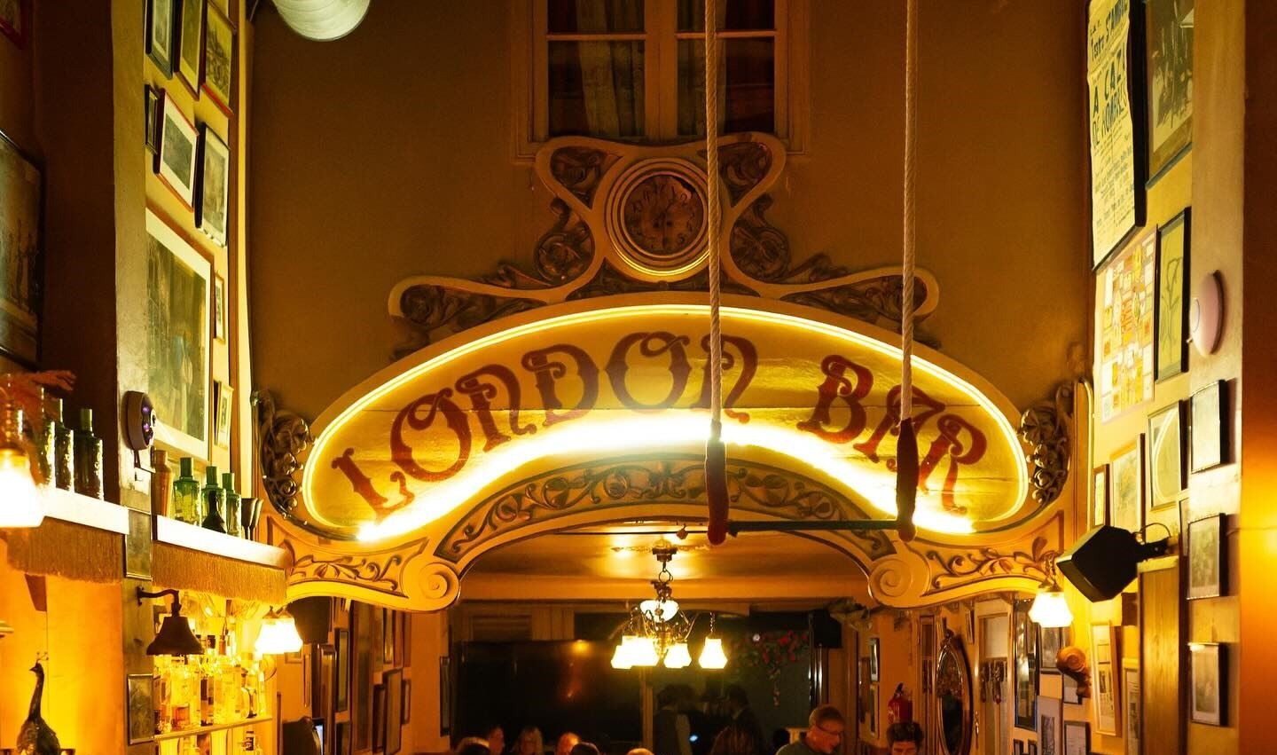 London Bar combina historia y ambiente vibrante, con una barra clásica, decoración art nouveau y un público animado disfrutando de la noche.