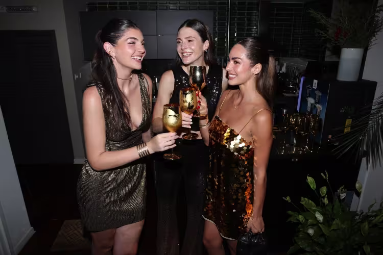 La imagen muestra tres chicas juntas sonriendo sosteniendo una copa de Johnnie Walker Gold Label Reserve