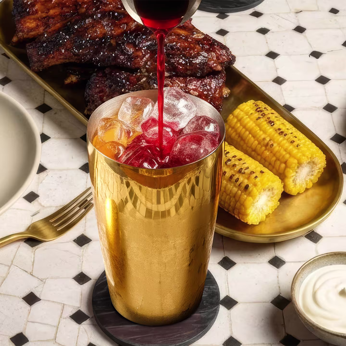 Un jigger toarnă un suc roșu într-un shaker de cocktail umplut cu gheață