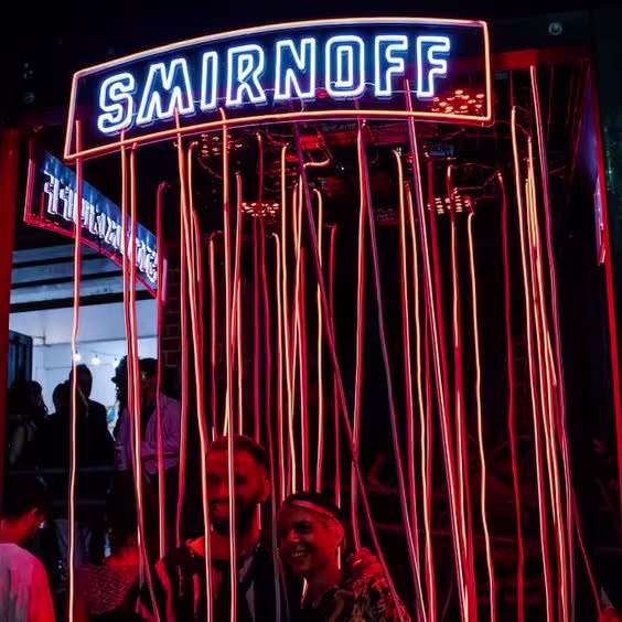 Los asistentes se toman una foto en el creativo stand iluminado de Smirnoff, diseñado para dejar huella en la memoria de la noche.