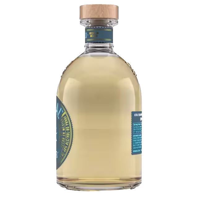 A clear glass bottle filled with light golden liquid, sealed with a wooden cap and featuring blue and gold labels.