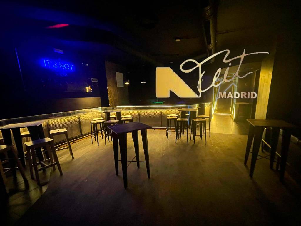 La imagen muestra el interior de la Discoteca Nuit en Madrid, con un ambiente moderno y minimalista. Las luces tenues en tonos azules y dorados crean una atmósfera elegante y sofisticada, ideal para disfrutar de la noche en un entorno exclusivo.