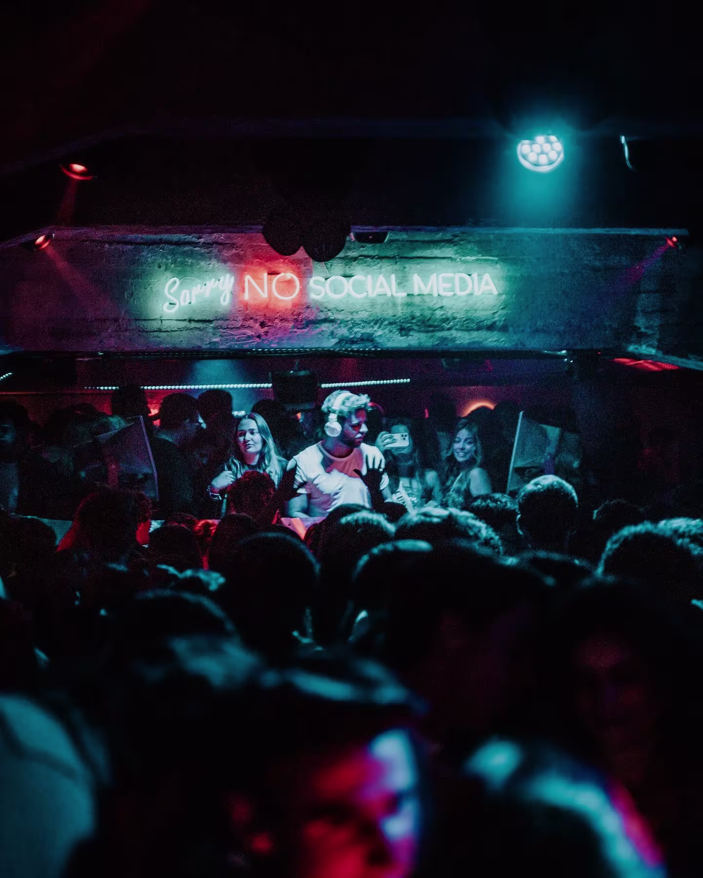 Ambiente nocturno en Toy Room, con luces neón, DJ en vivo y una multitud disfrutando de la música.