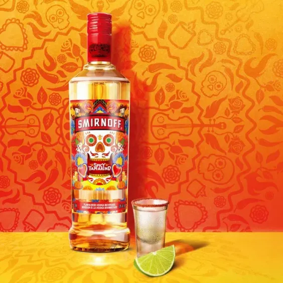Botella de Smirnoff Spicy Tamarind con un shot y un gajo de Lima