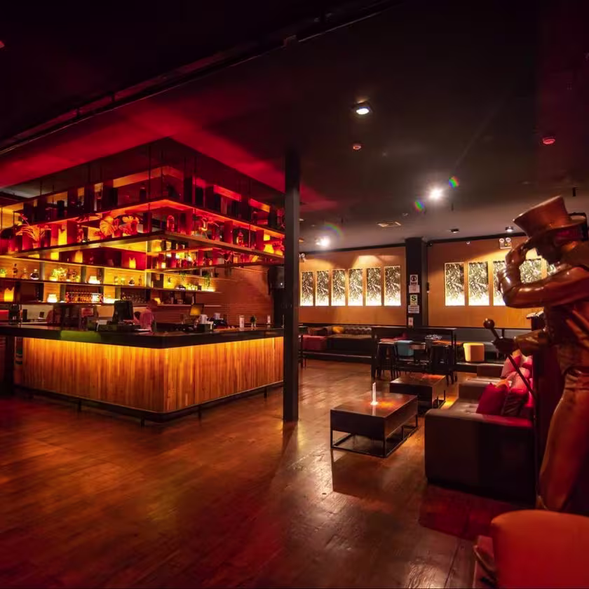 barra de una discoteca con luces y variedad de bebidas.