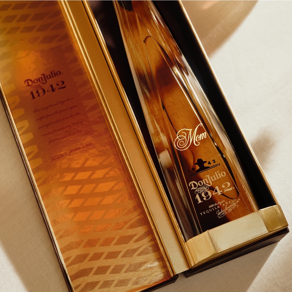 A bottle of Don Julio 1942 tequila in a gold-toned box, with Mom and a heart symbol engraved on the bottle.