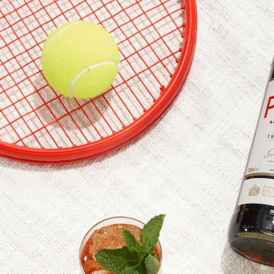A bottle of Pimm's next to a tennis racket