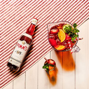 Pimm's drinks on a picnic basket with strawberries