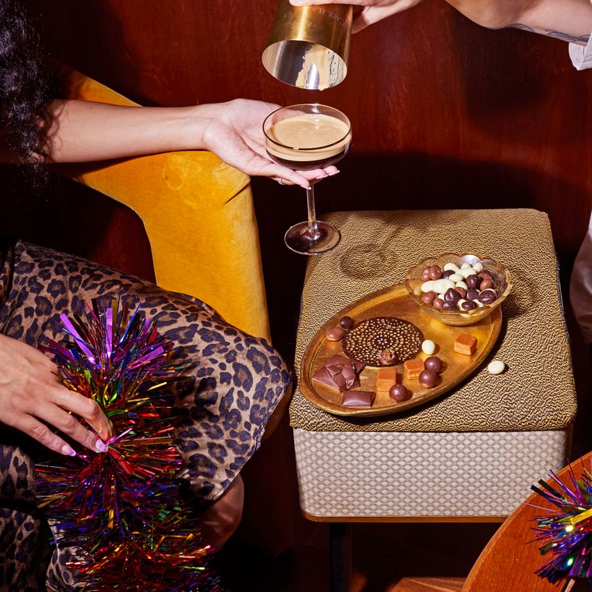 person pouring an espresso martini into a glass