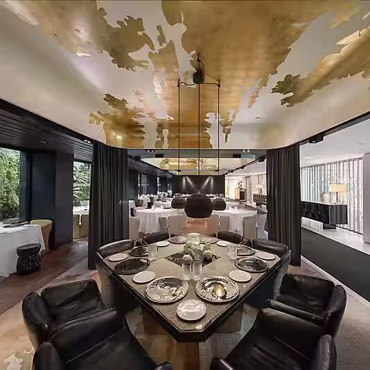 Mesa en el Mandarin Oriental Barcelona con un lujoso techo dorado y vistas a un entorno elegante y moderno, ideal para una experiencia exclusiva.