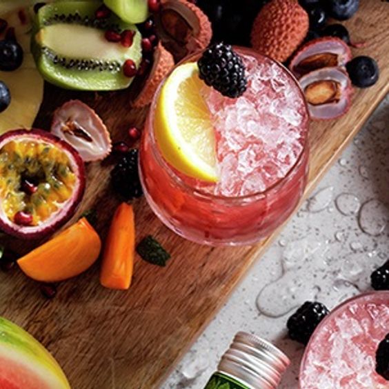Table with fruit and a gin bramble cocktail