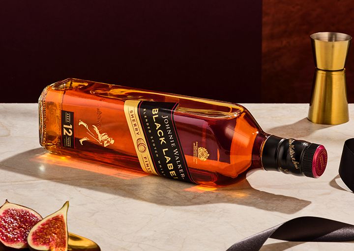 Johnnie walker black label shery finish on side over table with jigger