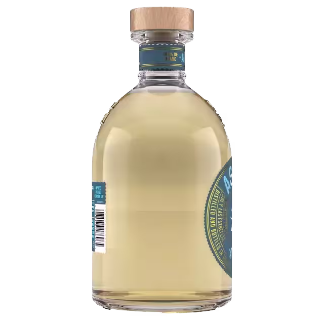 A clear glass bottle with a wooden cap, filled with light amber liquid, featuring a partial blue and gold label and a barcode.