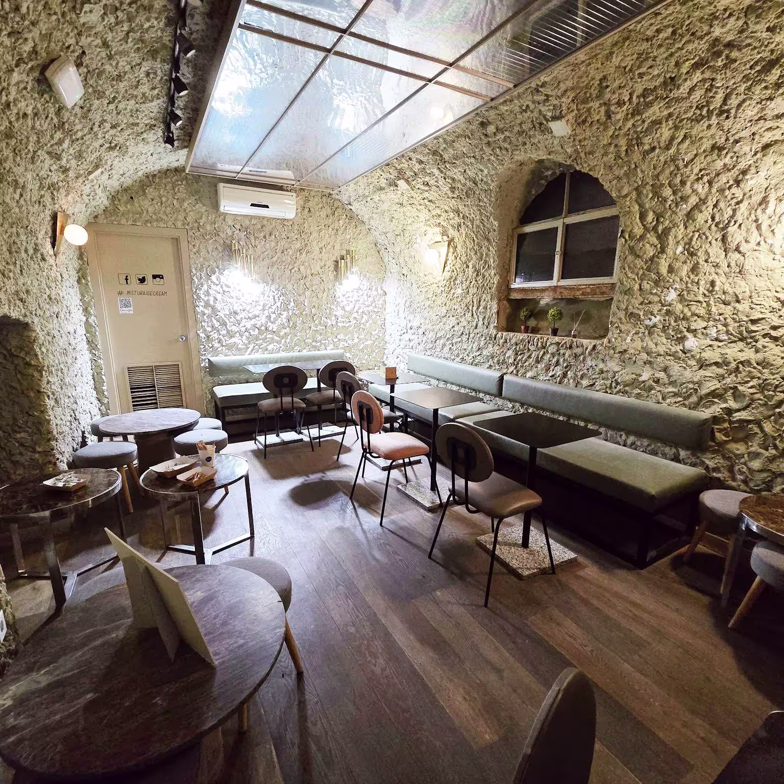 Interior de Mistura Plaza Mayor con paredes de piedra, luz cálida, techos abovedados y mesas bajas que invitan a una pausa tranquila.