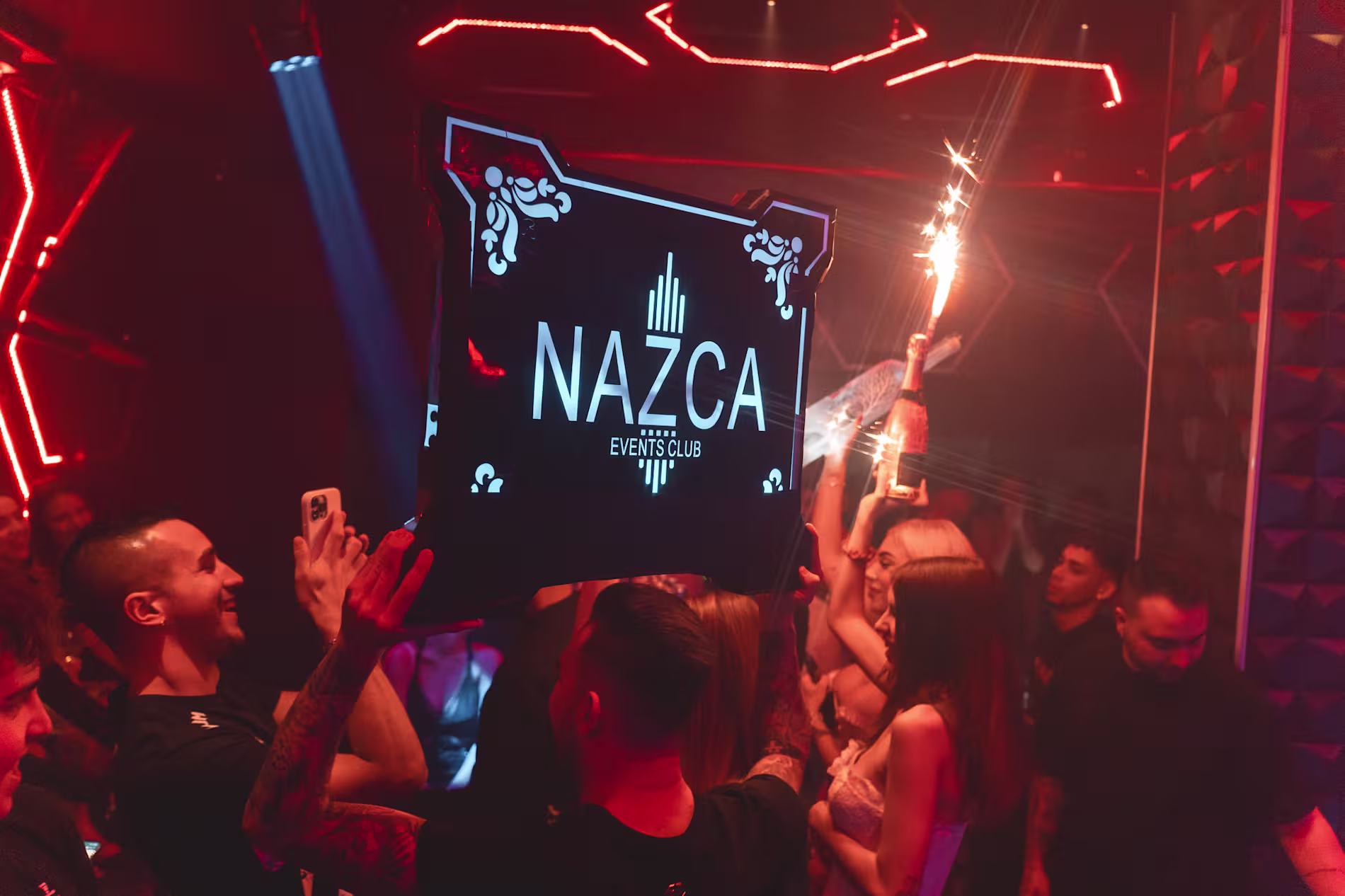 Nazca Events Club con luces rojas, champán y ambiente festivo, creando noches vibrantes y llenas de emoción.