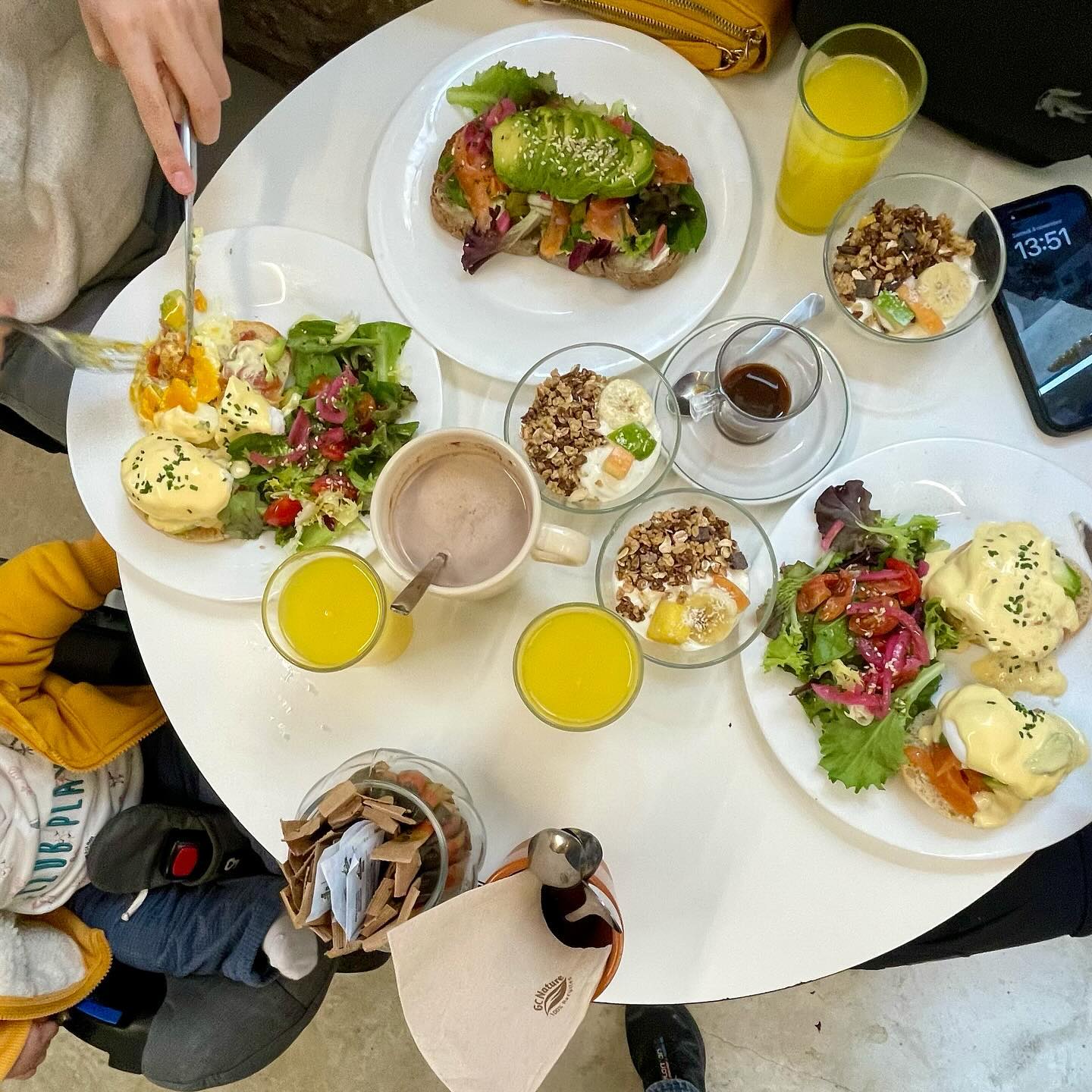 Mesa en Desal Café con huevos benedict, tostadas con aguacate, zumos, yogur con fruta y granola, café, cacao y ensaladas frescas.