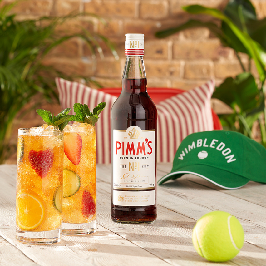 Jug of Pimm's with a Wimbledon cap and tennis ball pictured beside them