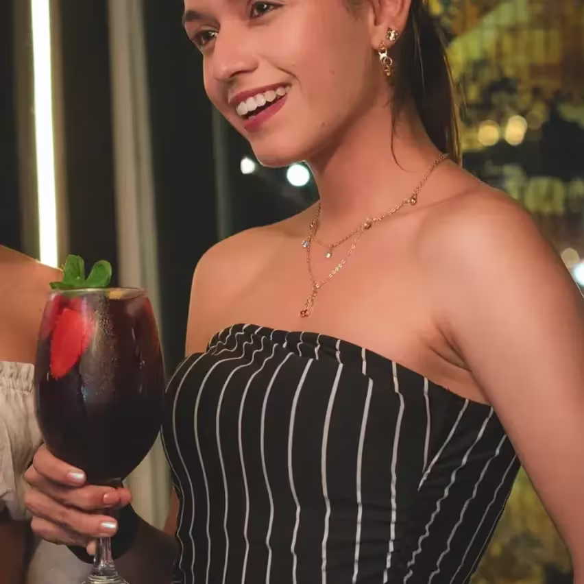 Una mujer con un cóctel en Épico Bar
