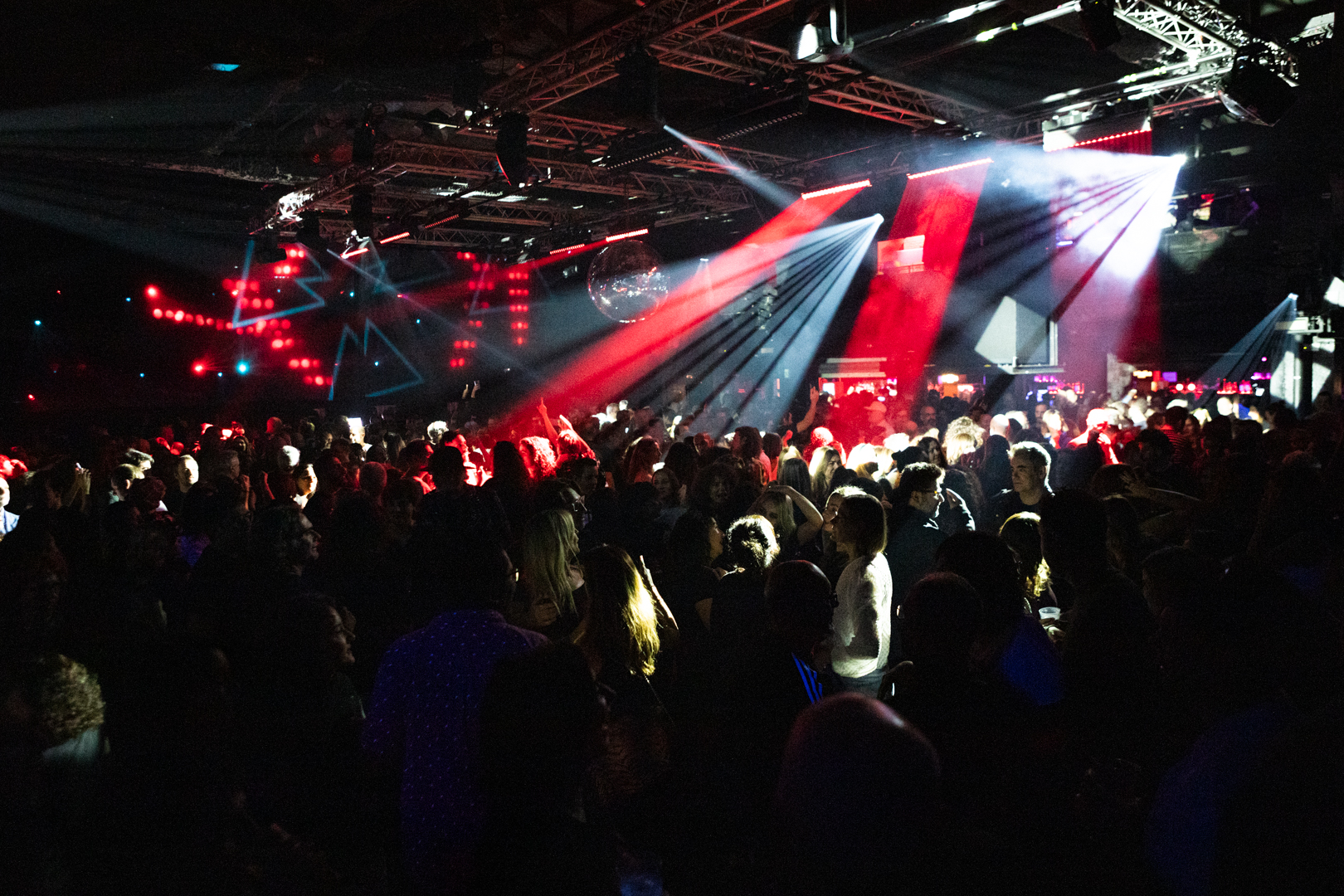 Multitud disfrutando de la pista de baile en Razzmatazz, con luces rojas, efectos visuales y una atmósfera vibrante de fiesta.