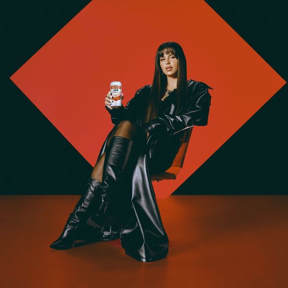 En la imagen, se puede observar a la artista Nathy Peluso sentada, posando con una lata de Smirnoff Ice