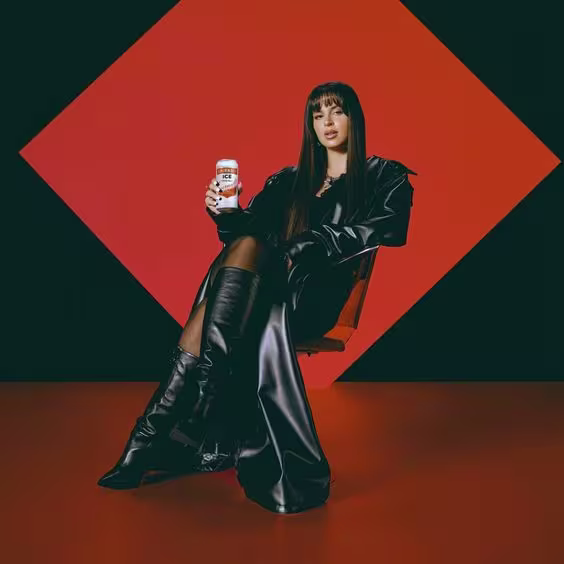 En la imagen, se puede observar a la artista Nathy Peluso sentada, posando con una lata de Smirnoff Ice