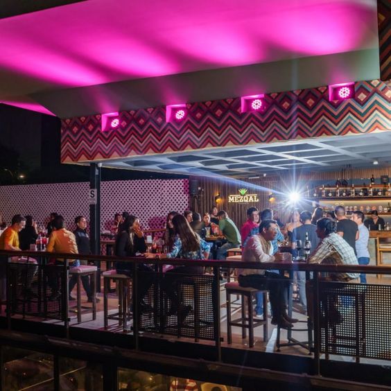 Mesas afuera del restobar con personas sentadas