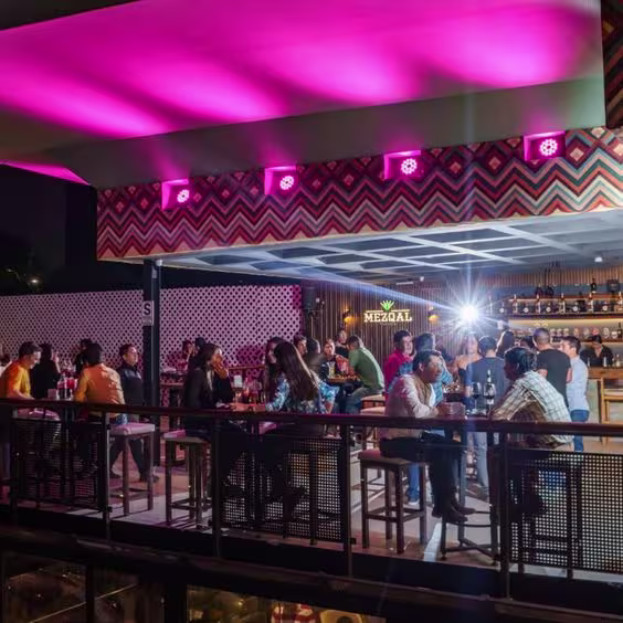 Mesas afuera del restobar con personas sentadas
