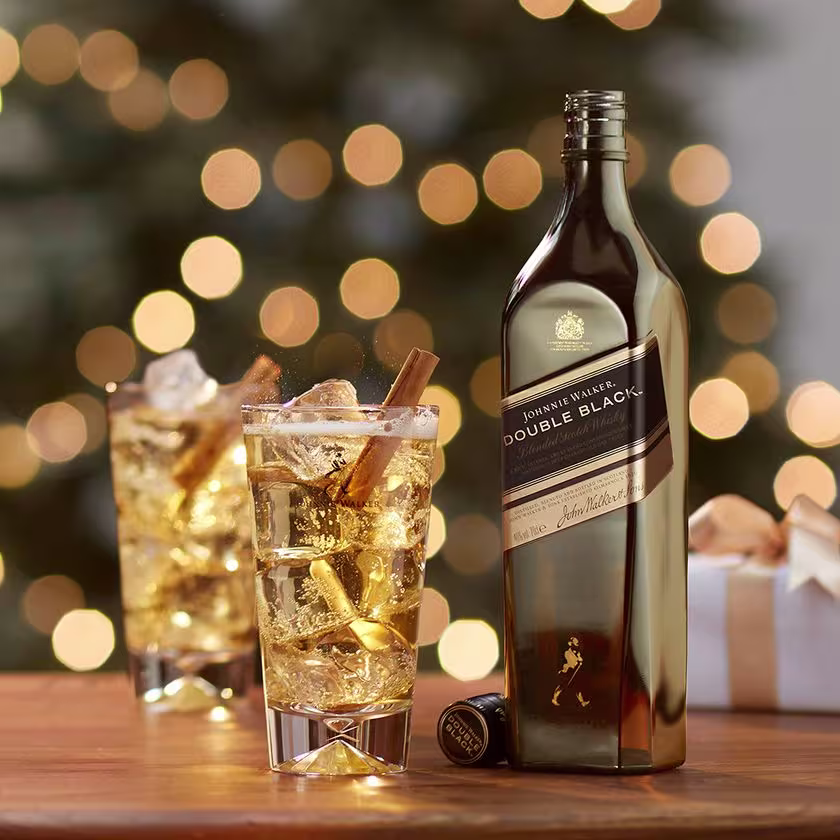 La imagen muestra un whisky Johnnie Walker Double Black y dos vasos con cócteles elaborados con este mismo destilado.