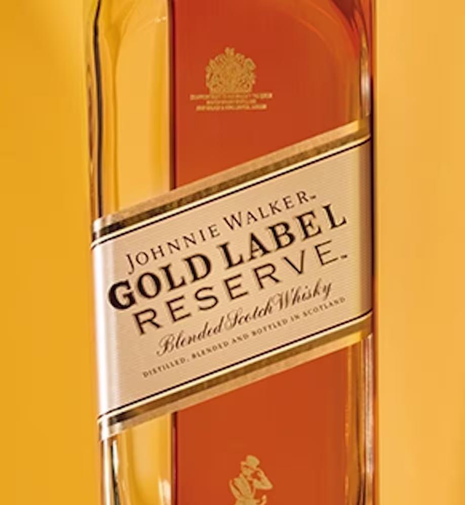 primer plano de la etiqueta johnnie walker gold label reserve junto a otras botellas