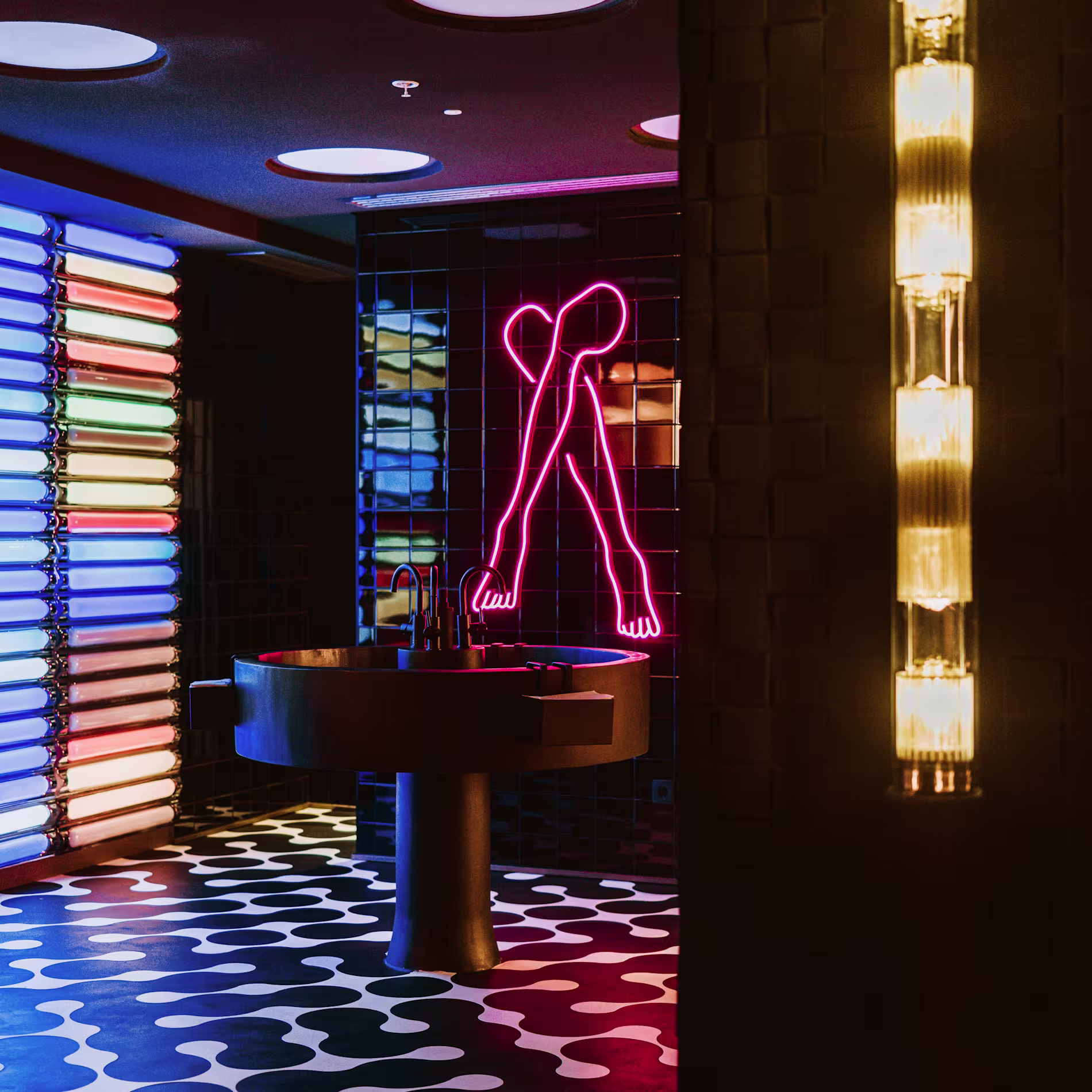 80 Grados Castellana sorprende con un baño psicodélico lleno de neones, lavabos circulares y una pared de luces que parece sacada de una instalación artística.