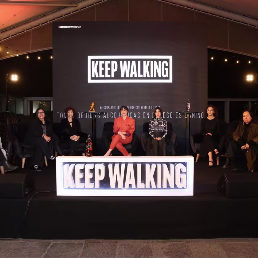 La imagen muestra el escenario con las seis mujeres cineastas sentadas y un letrero grande que dice: keep walking.