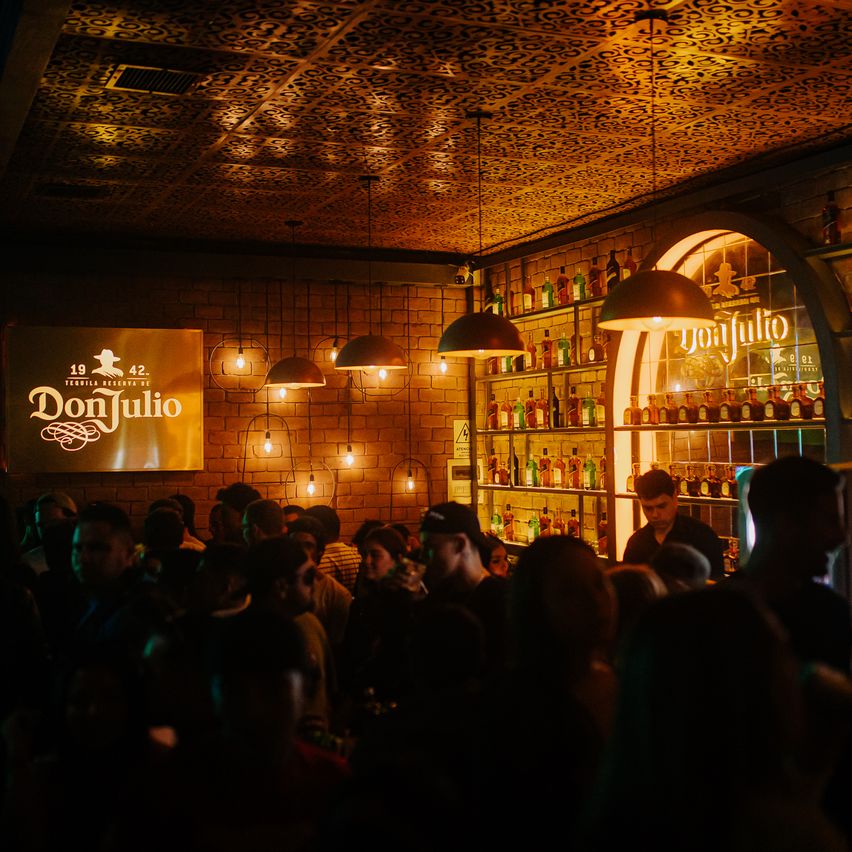 En la imagen se ve la barra de Tequila don Julio repleta de gente.