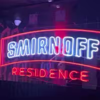 Cartel fluorescente con la leyenda "Smirnoff Residence"