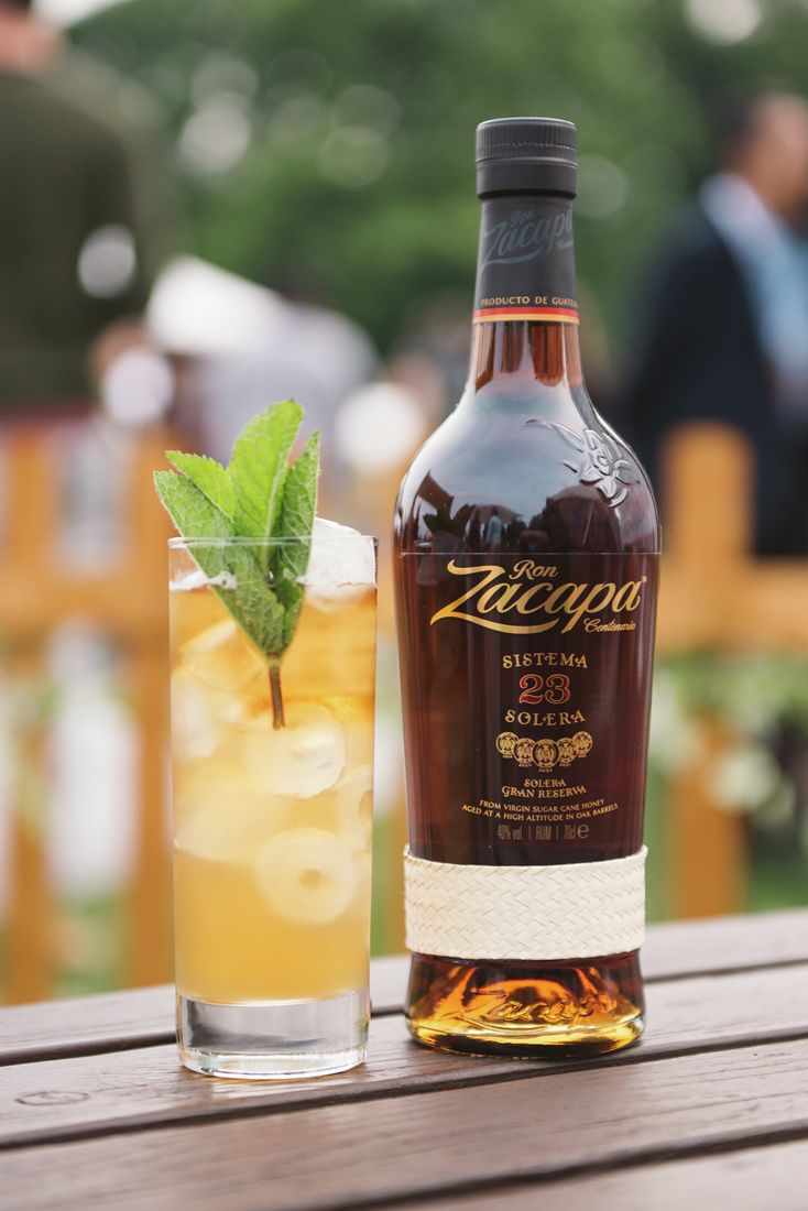 La imagen muestra una botella de ron Zacapa 23 junto a un vaso largo con un cóctel preparado con dicho destilado.